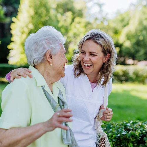 senior woman walking with caregiver