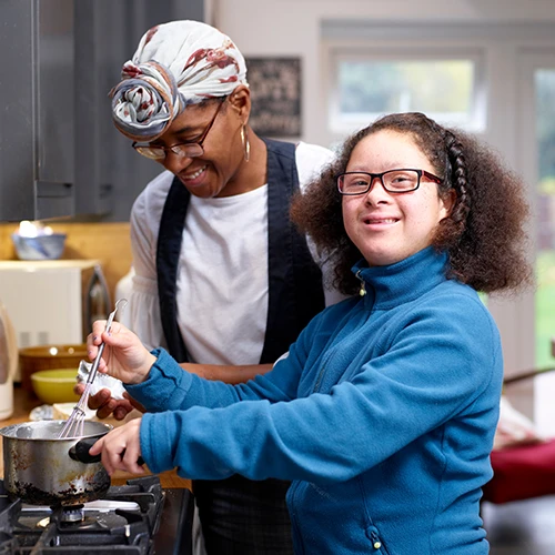 Mother with daughter with Down Syndrome cooking together 